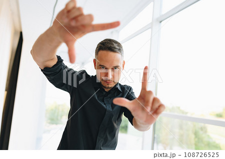 Portrait of a man in black shirt posing in photostudio Portrait of a man in black shirt posing in photostudio 108726525