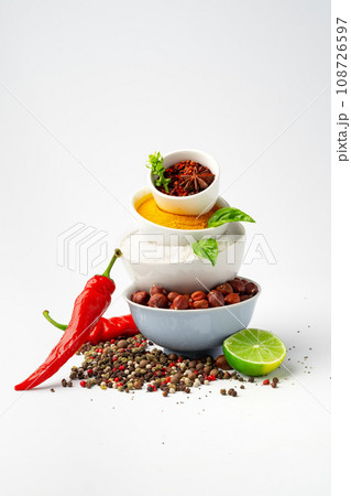 Bowls with spices and cooking ingredients on white background 108726597