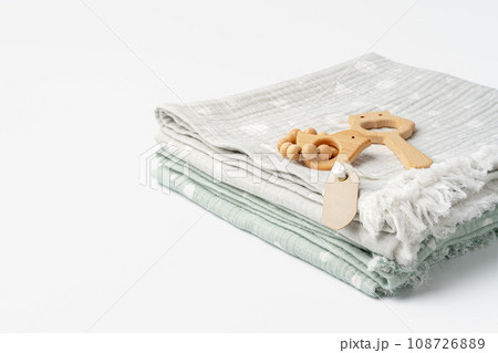 Muslin swaddle blanket with wooden toys on white background Muslin swaddle blanket with wooden toys on white background 108726889