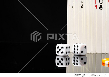 Playing cards and dice cubes on black background Playing cards and dice cubes on black background 108727097