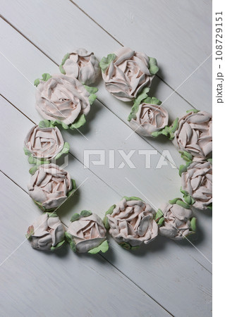 Flowers from marshmallows. Homemade marshmallows. Laid out in the shape of a heart. On white boards. View from above. Flowers from marshmallows. Homemade marshmallows. Laid out in the shape of a heart. On white boards. View from above. 108729151