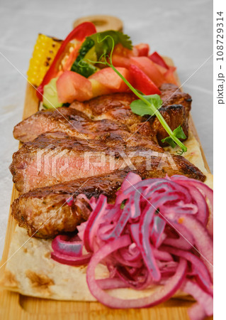 Beef steak cut on slices served with garnish Beef steak cut on slices served with garnish 108729314