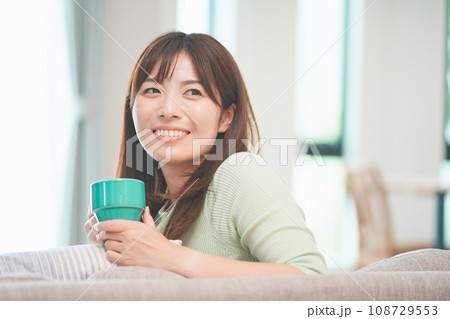 リビングでコーヒーを飲んでリラックスする女性 108729553