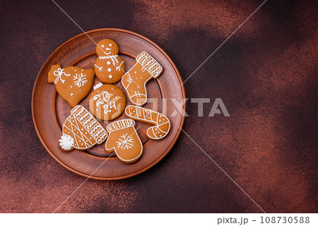 Beautiful Christmas gingerbread cookies of different colors on a ceramic plate 108730588