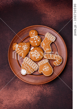 Beautiful Christmas gingerbread cookies of different colors on a ceramic plate 108730590