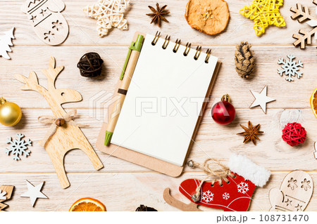 Top view of notebook on wooden background made of Christmas decorations. New Year concept 108731470