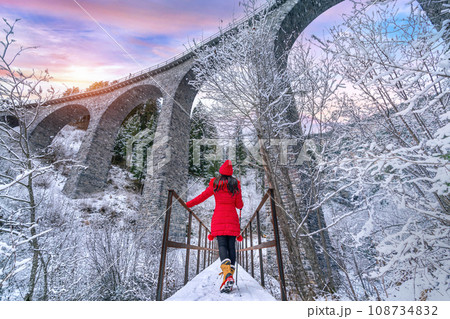 Tourist visiting Landwasser Viaduct world heritage in Swiss Alps snow winter scenery, Switzerland. 108734832