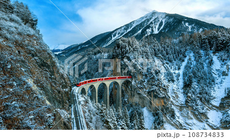 Landscape of Train passing through famous mountain in Filisur, Switzerland. Landwasser Viaduct world heritage with train express in Swiss Alps snow winter scenery. 108734833