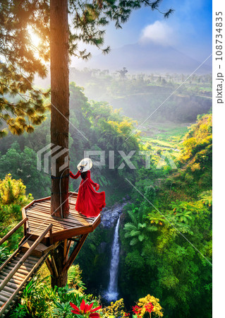 Tourist standing at Air Terjun Kedung Kayang waterfall at sunrise, Indonesia. Tourist standing at Air Terjun Kedung Kayang waterfall at sunrise, Indonesia. 108734835