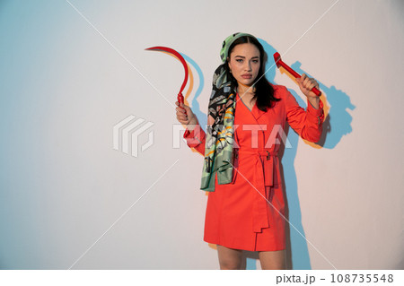 a woman in an orange dress holds a working tool a woman in an orange dress holds a working tool 108735548