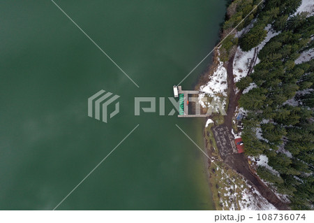 Aerial view of a lake boat dock. Flying above a vessel pier Aerial view of a lake boat dock. Flying above a vessel pier 108736074