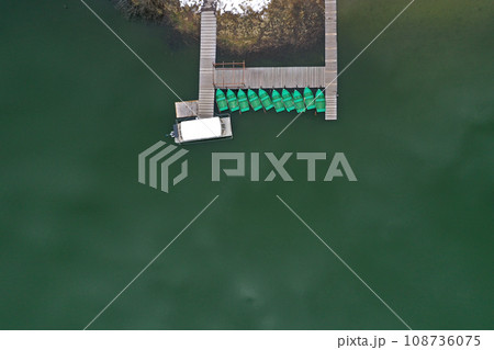 Aerial view of a lake boat dock. Flying above a vessel pier Aerial view of a lake boat dock. Flying above a vessel pier 108736075
