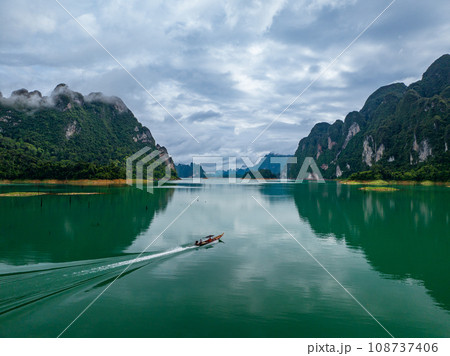 Aerial drone view of tourist boat on the lake of tropical Mountain peak , Khao Sok National Park, Thailand 108737406
