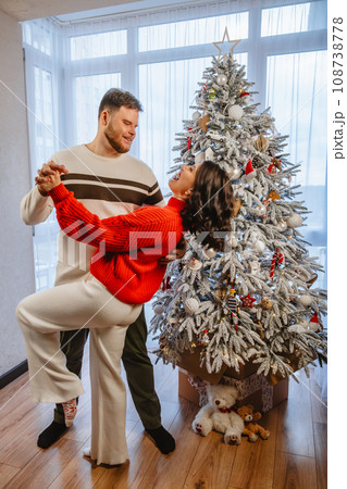 lovely couple dancing in front of christmas tree lovely couple dancing in front of christmas tree 108738778