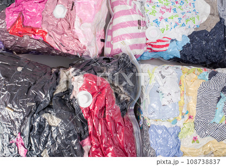 Background of vacuum bags with colorful clothes for storing compact size items. Modern technology, close-up 108738837