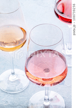 Wine glasses at a tasting. Rose, red, and white wine, drinks on a table Wine glasses at a tasting. Rose, red, and white wine, drinks on a table 108739256