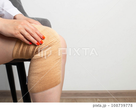 Orthopedic knee brace on a girl's leg. The concept of an elastic knee brace to support the knee joint after an injury. Copy space for text 108739778