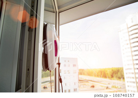 Automatic vacuum robot window cleaner washes glass in the apartment, balcony frame, Copy space for text 108740157