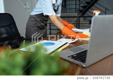 Woman maid cleaning and wiping the table with microfiber cloth in office Woman maid cleaning and wiping the table with microfiber cloth in office 108741730