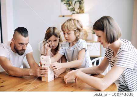 Loving young parents with little son and daughter enjoy playtime on leisure Loving young parents with little son and daughter enjoy playtime on leisure 108743039