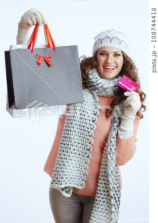 smiling trendy woman in sweater, mittens, hat and scarf 108744418