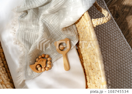 Muslin blanket and wooden toys in baby cradle Muslin blanket and wooden toys in baby cradle 108745534