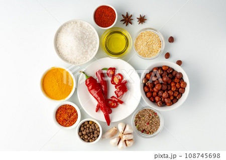 Bowls with spices and cooking ingredients on white background 108745698