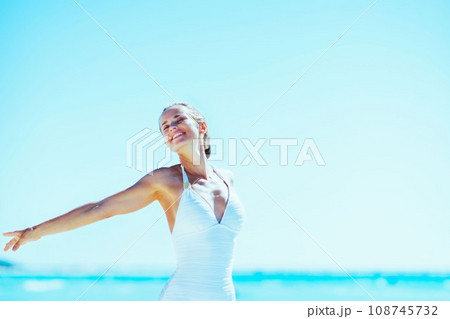 young woman walking rejoicing on sea sho young woman walking rejoicing on sea sho 108745732