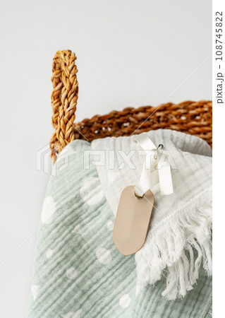 Soft cotton blanket in a straw basket on white background 108745822