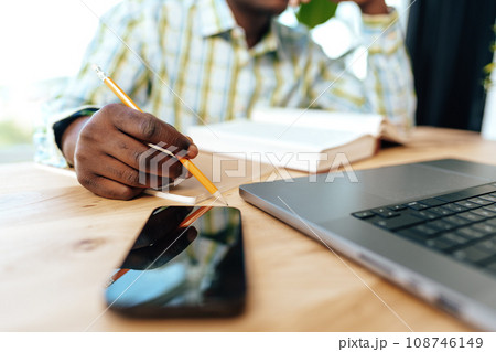 Close up photo of african businessman making notes while sitting at the table in office 108746149