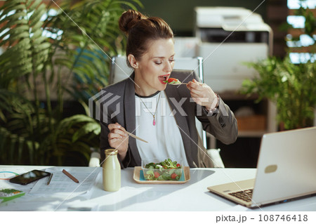 business owner woman in green office eating salad business owner woman in green office eating salad 108746418