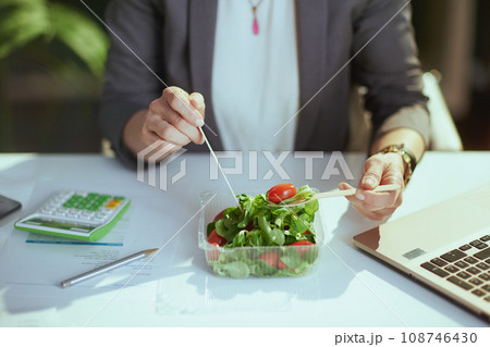 Modern business woman in green office eating salad 108746430