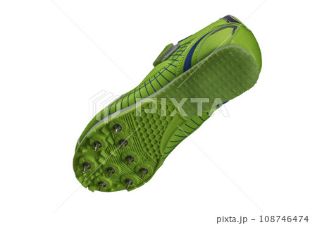 Green sole with spiked sneakers on a white background. Sport shoes. Green sole with spiked sneakers on a white background. Sport shoes. 108746474