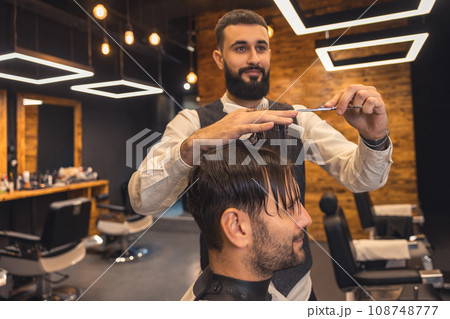 Man hairdresser making hairstyle for client. 108748777