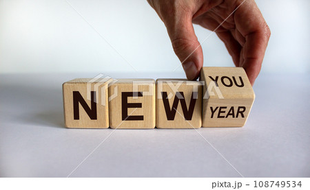 Hand turns a cube and changes the expression 'new year' to 'new you'. Beautiful white background. Copy space. Business concept. 108749534