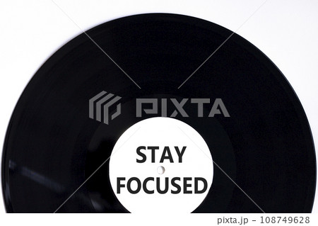 Stay focused symbol. Concept words Stay focused on beautiful black vinyl disk on a beautiful white table white background. Business, support, motivation, psychological stay focused concept. Copy space 108749628