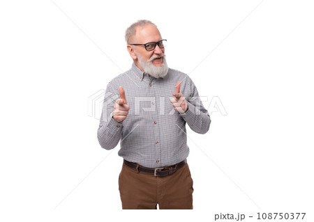 a handsome old man with a mustache and a beard in glasses is dressed in a shirt and trousers on a 108750377