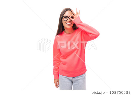 portrait of a young positively energetic european model woman with long black hair dressed in a pink 108750382
