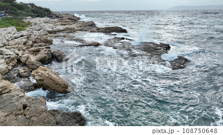 Aerial view of sea waves hitting the rocks with drone 108750648