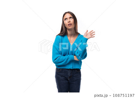young slender well-groomed European brunette woman dressed in a blue cardigan on a white background young slender well-groomed European brunette woman dressed in a blue cardigan on a white background 108751197