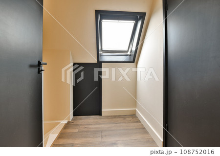 an empty room with wooden floors and skylights on the roof window is visible in the corner to the left 108752016