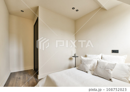 a bedroom with white bedding and wood flooring in front of the door to the room is very light a bedroom with white bedding and wood flooring in front of the door to the room is very light 108752023