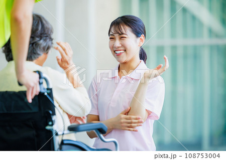 車椅子のシニアの女性と若い介護士 108753004