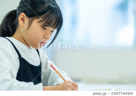 塾で勉強をする小学生の女の子。撮影協力：有明教育芸術短期大学 108754469