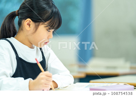 塾で勉強をする小学生の女の子。撮影協力：有明教育芸術短期大学 108754538