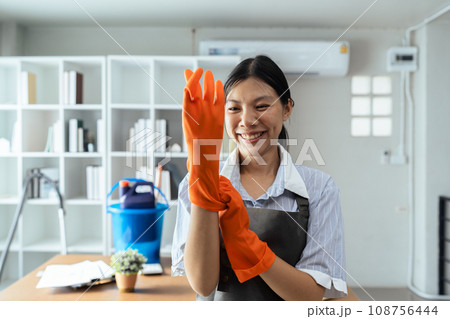 Female housekeeper smile and wearing glove, preparing to clean office 108756444