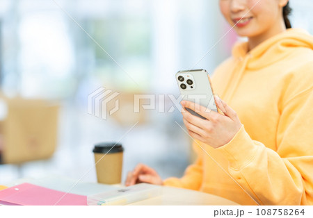 スマホを操作する女子大学生。（パーツモデル）撮影協力：有明教育芸術短期大学 108758264