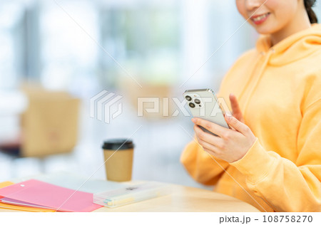 スマホを操作する女子大学生。(パーツモデル)撮影協力:有明教育芸術短期大学 スマホを操作する女子大学生。(パーツモデル)撮影協力:有明教育芸術短期大学 108758270