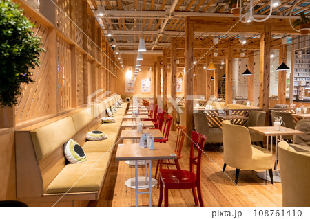 Loft style restaurant with textured wooden walls. Cafe restaurant in wooden style. There are plenty of tables with chairs and armchairs. Empty coffee without people. Loft style restaurant with textured wooden walls. Cafe restaurant in wooden style. There are plenty of tables with chairs and armchairs. Empty coffee without people. 108761410