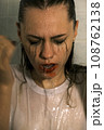 Portrait of a young girl with dripping makeup standing in the shower. Vertical Shot Portrait of a young girl with dripping makeup standing in the shower. Vertical Shot 108762138